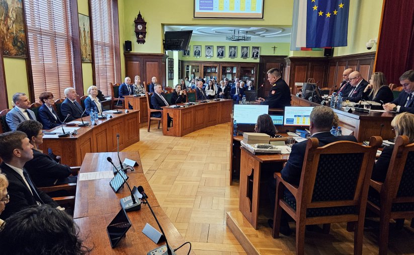 Sala Rycerska podcza sesji, radni siedzący przy stołach, po prawej stół prezydialny, w drugim planie widownia