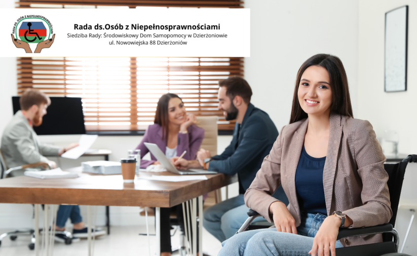 Biuro, osoby rozmawiające przy stole, na pierwszym planie uśmiechnięta, siedząca na wózku niepełnosprawna kobieta