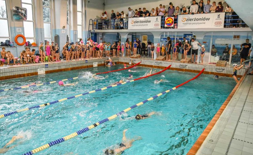 Basen kryty, dokoła ludzie kibicujący pływakom