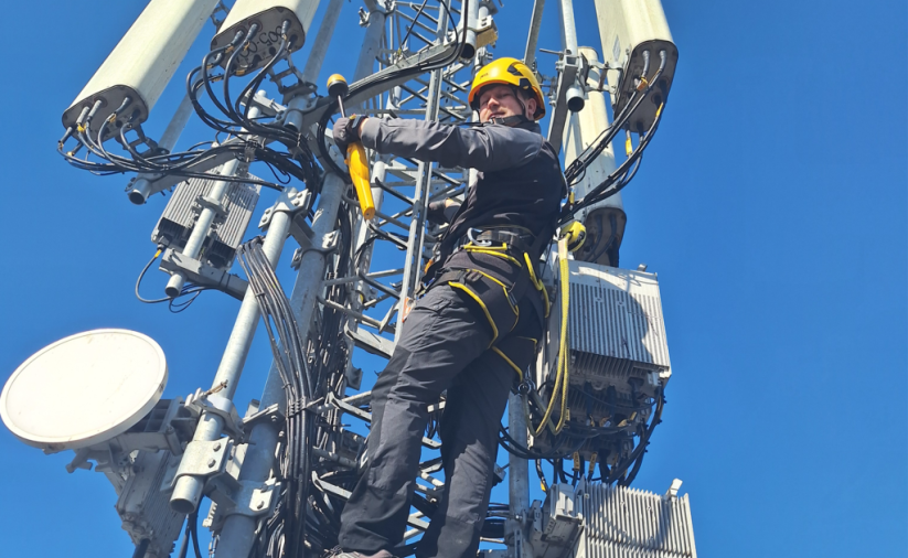 pracownik robót wysokościowych na nadajniku telefonii komórkowej