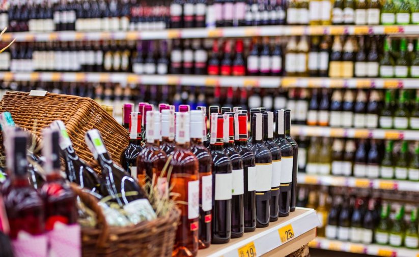 sklep z alkoholem, na półka stoją rzędy butelek w różnych kolorach