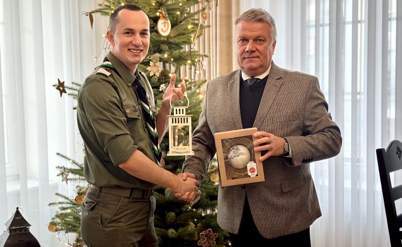 ć zdjęcie przedstawiające moment przekazania światła, burmistrza z komendantem Tomaszem Tkaczem przy płomieniu