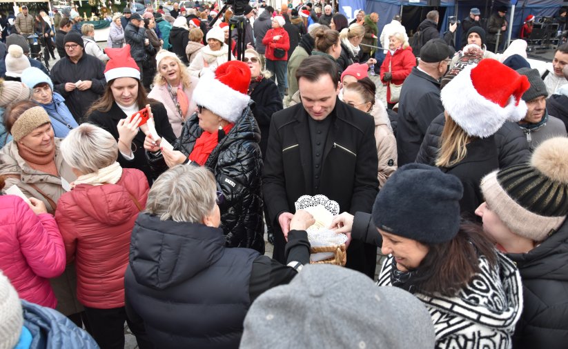 Wigilia miejska, ludzie dzielący się opłatkiem