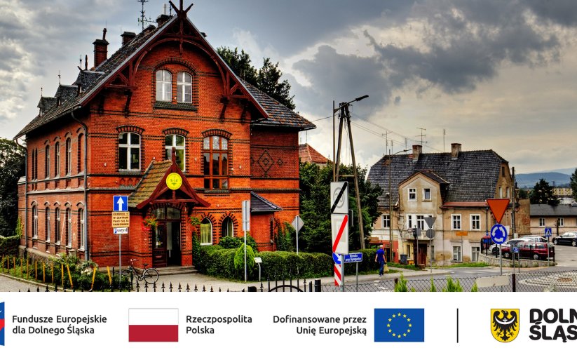 Budynek z czerwonej cegły, u dołu logotypy partnerów projektu