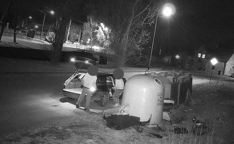 czarno-białe zdjęcie z fotopułapki, przedstawiające mężczyzn nielegalnie wyrzucających odpady