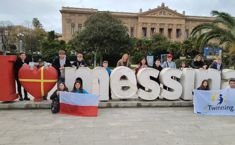 Duże litery I love Messina na tle miasta, przy literach stoją dzieci