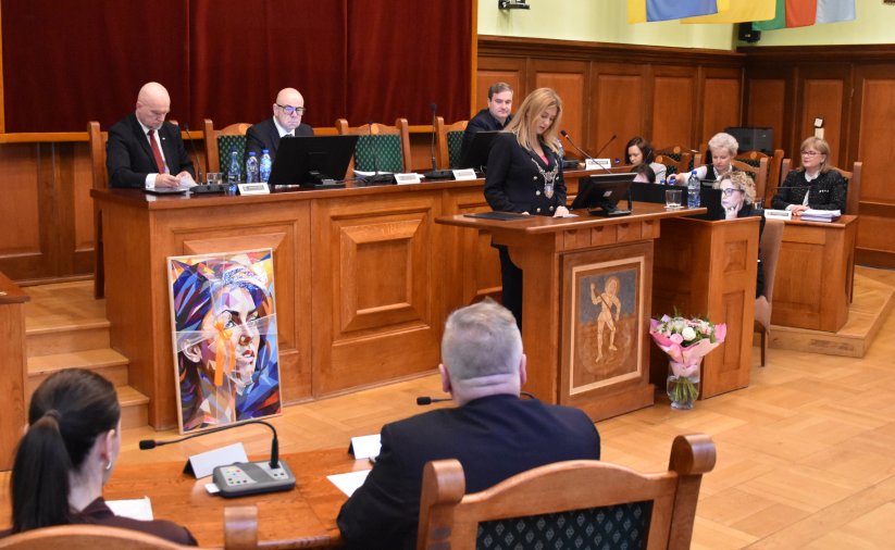 Sesja, przy mównicy przewodnicząca rady, za nią stół prezydialny i trzech wiceprzewodniczących