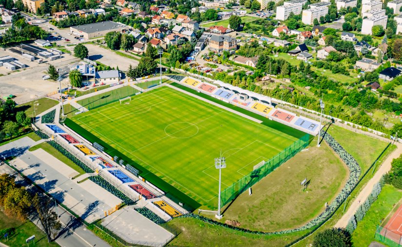 Stadion z góry, obok duży parking i plac targowy