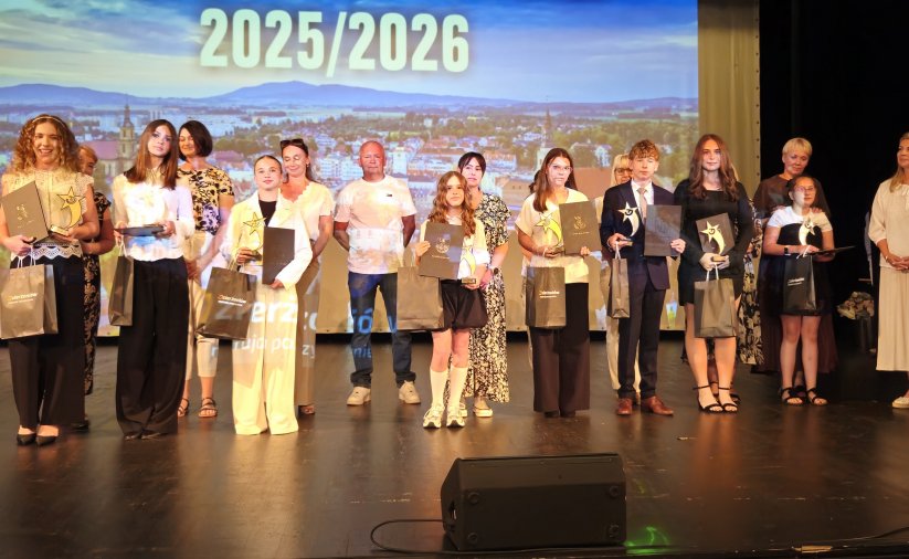 Grupa uczniów na scenie z dyplomami 