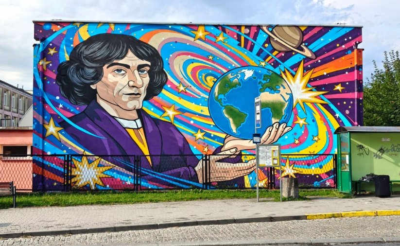 Kolorowy mural przedstawiający kopenika trzymającego na dłoni kulę ziemską