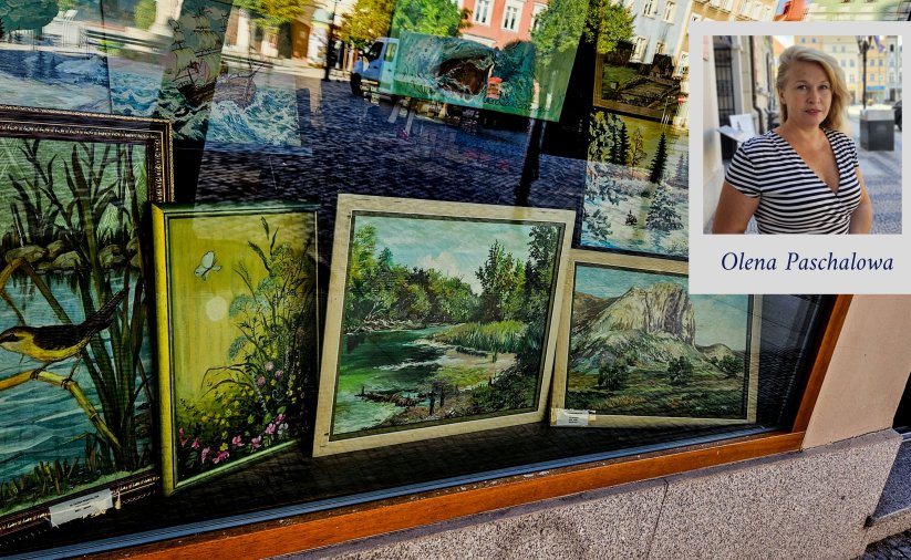 Witryna okienna z obrazami przedstawiającymi naturę i zdjęciem autorki