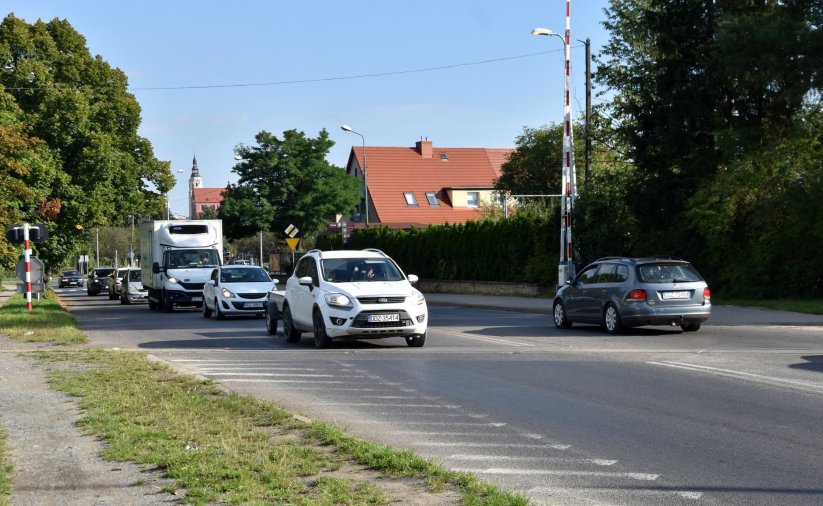 Auta jadące przez przejazd kolejowy