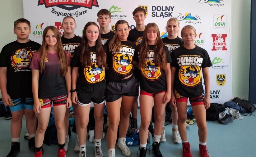 Zawodniczki i zawodnicy w klubowych czarnych koszulkach na grupowym zdjęciu