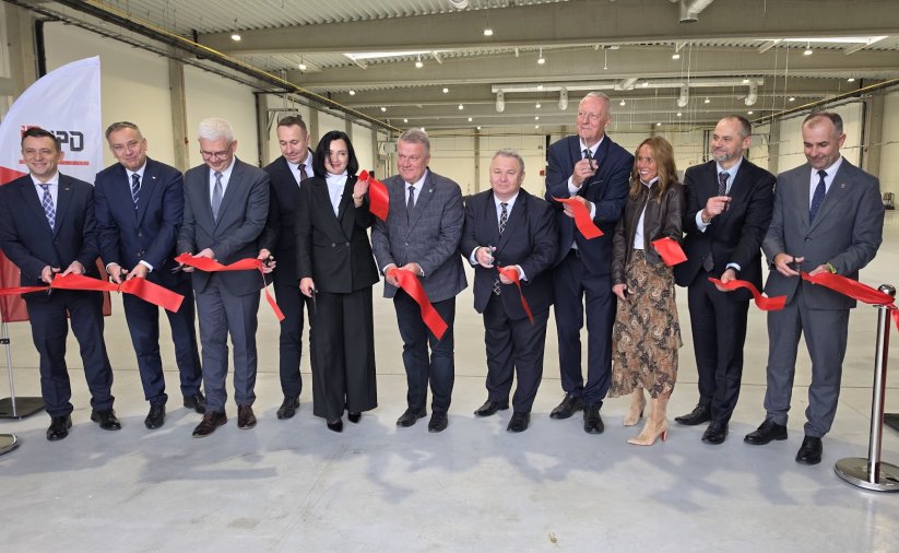 11 osób przecina wstęgę na otwarciu nowej hali produkcyjnej IPD w Dzierżoniowie