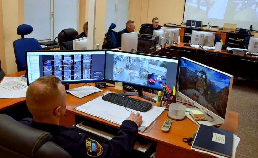 straznicy miejscy przed monitorami z monitoringu miejskiego
