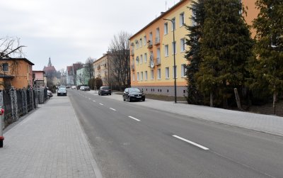 Ulica Słowiańska po remoncie, po bokach nowe chodniki, za nimi domy jedno i wielorodzinne