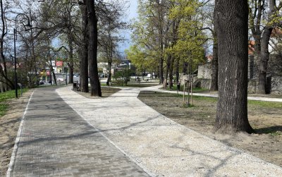 Nowe alejki w parku miejskim, po prawej wysokie kamienne mury
