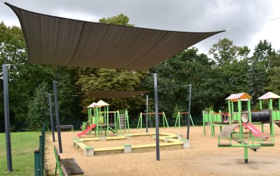 Żagle zacieniające na dużym placu zabaw z piaskową nawierzchnią