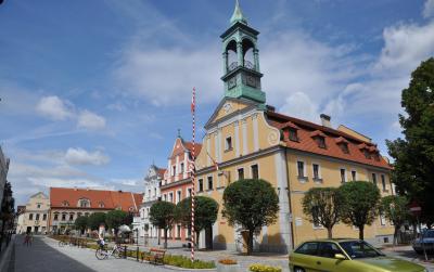 Budynek ratusza w Kluczborku otoczony drzewami