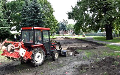Koparka wybierająca ziemię z terenu zielonego