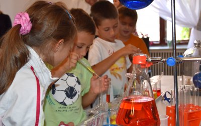 Dzieci przeprowadzające eksperyment chemiczny, na stole fiolki labolatoryjne