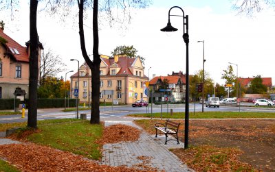 Park w zielenii złotych liściach, po środku alejka