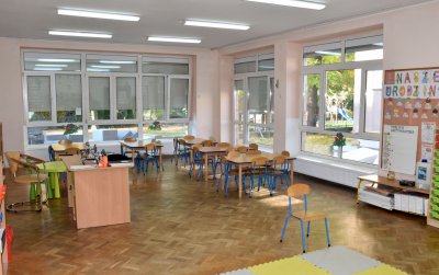 Wnętrze sali przedszkolnej z dużymi oknami
