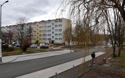 Chodnik i pusta droga, w tle długi blok