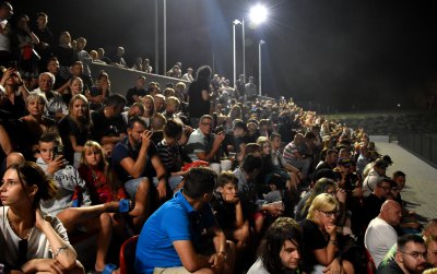 Stadion wieczorem z trybuną wypełnioną kibicami 