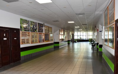 Korytarz szkolny, na jego końcu duże okna