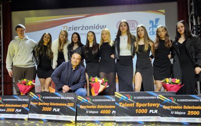 Grupowe zdjecie zapaśniczek na scenie, po środku trener