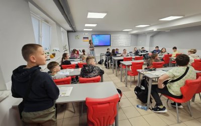 Duża klasa, uczniowie siedzą w ławkach zamiast tablicy ekran multimedialny