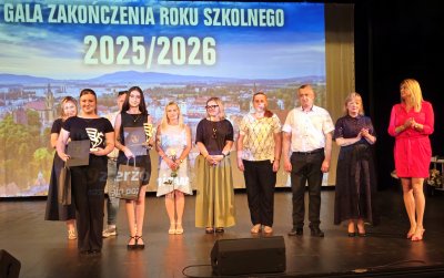 Grupa uczniów na scenie, obok nich przewodnicząca rady i zatępca burmistrza