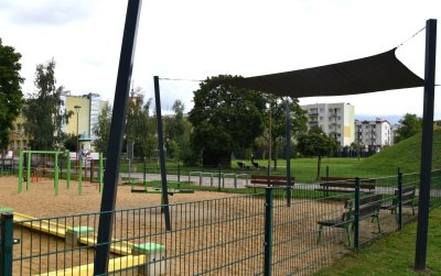 Plac zabaw z piaszczystą nawierzchnią, cześć zasłonięta żaglem dającym cień