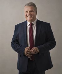 Dariusz Kucharski stojący z uśmiechem