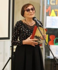 Zbigniew Czendlik przy mikrofonie z książką w dłoniach