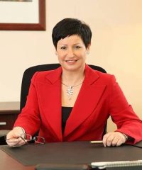 Elżbieta Nowakowska-Akkermans w czerwonej kamizelce przy biurku