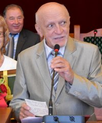 Janusz Kaczmarzyk z żoną stojący przy mównicy