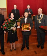 Leszek Tymcio podczas odbioru tytułu, obok burmistrz oraz przwewodniczący i wiceprzewodniczący rady miejskiej