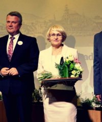 Zofia Mirek z medalem i kwiatami, po bokach burmitrz, przewodniczacy i wiceprzeodniczący rady