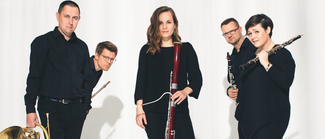 Pięcioro muzyków trzymających instrumenty w śroku kobieta, białe tło