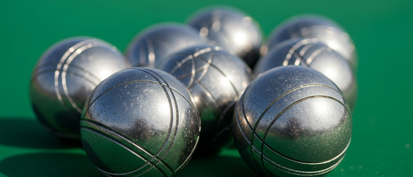 Osiem kul do gry w Petanque na zielonym tle