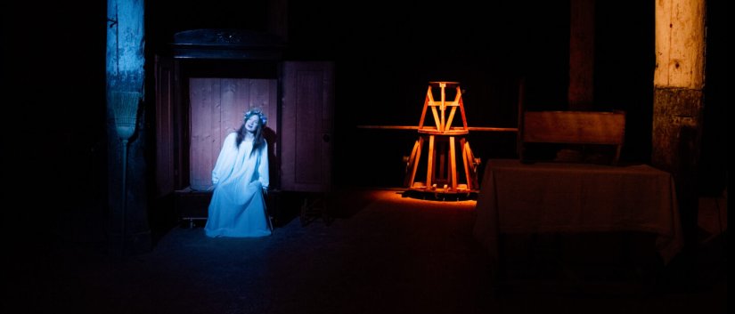 Scena teatralna z oświetloną kobietą w długiej sukni, fot. F. Pobłocki