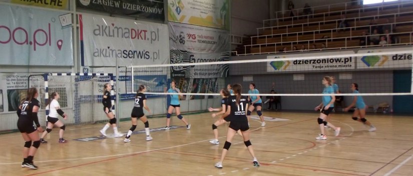 Dwie dziewczęce drużyny grające w siatkówkę w hali sportowej
